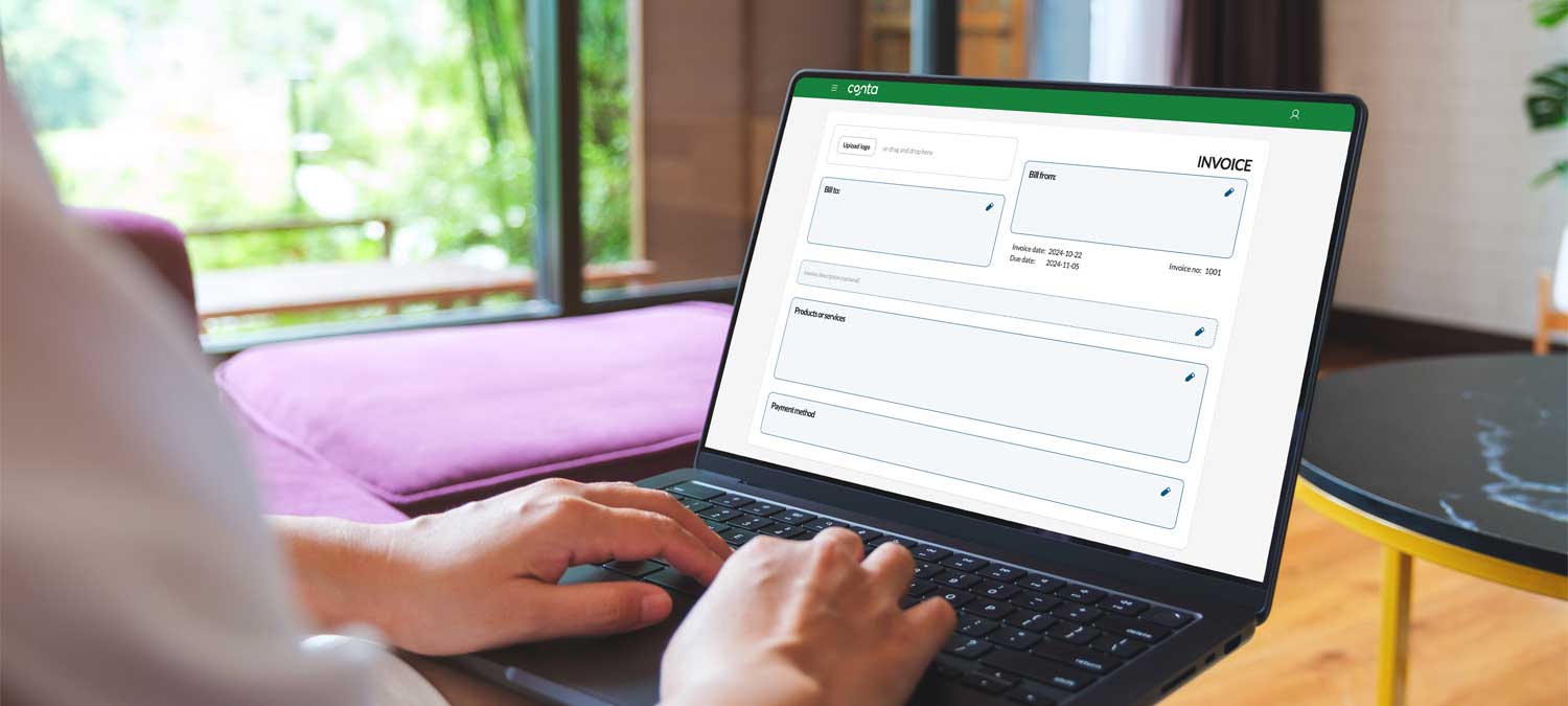 przejście z papieru na program cyfrowy sterta papierowych faktur obok monitora z cyfrowym programem księgowym