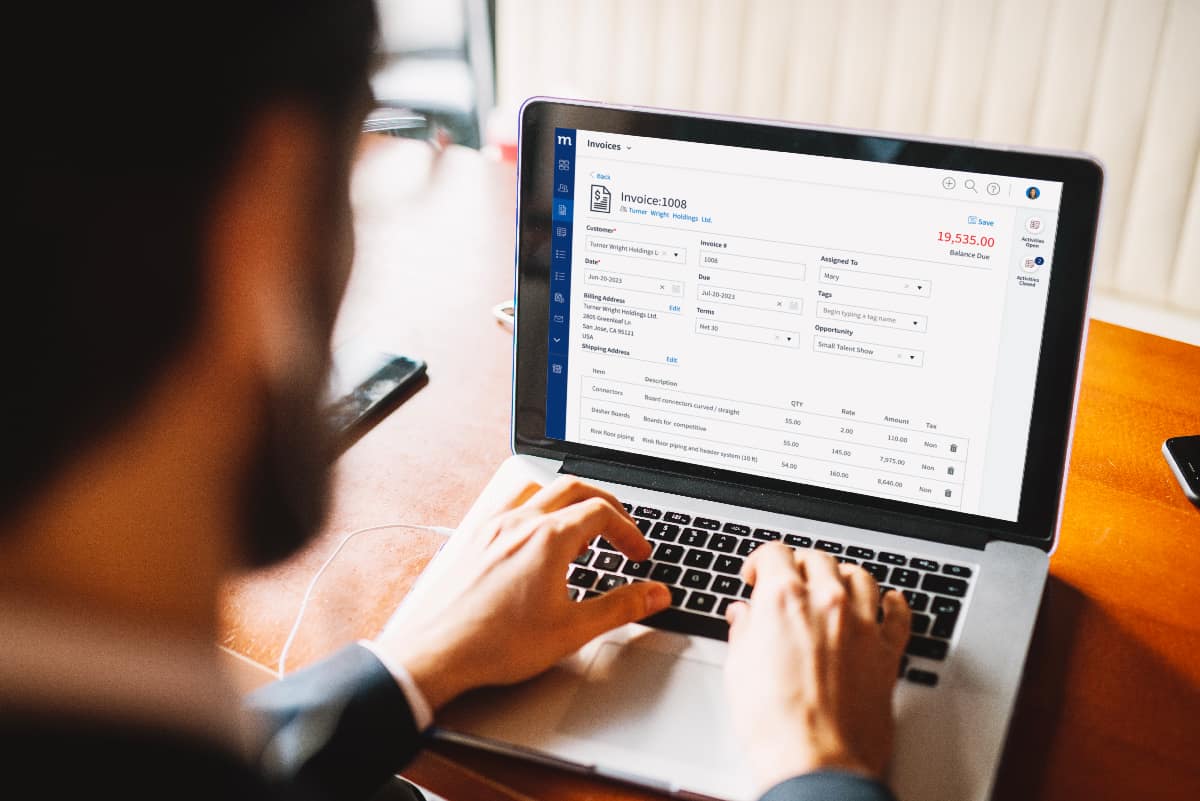 wprowadzanie danych do faktury online ręce na klawiaturze wpisujące dane klienta w formularz faktury online